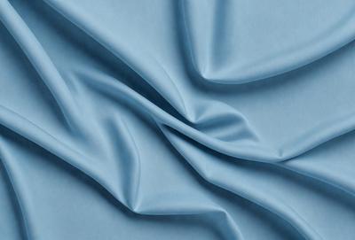 The primary subject of the image is a blue fabric, which is the main object, scene, or focus of the image. The setting or background is a blue surface, which adds to the overall atmosphere. The visual style of the image is a close-up of the blue fabric, showcasing its texture and details. The colors and mood of the image are predominantly blue, creating a calm and serene atmosphere.