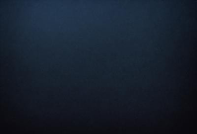 The primary subject of the image is a dark blue background. The setting is a vast, open space with no visible objects or landmarks. The visual style is a simple, monochromatic design. The colors and mood are predominantly dark and moody, with a hint of mystery.