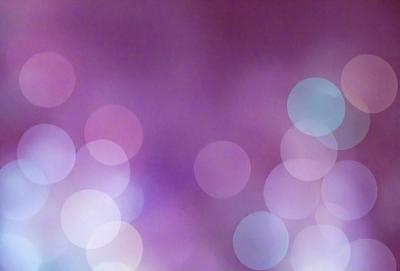 The primary subject of the image is a purple background with a pattern of white circles. The setting is a purple background with a pattern of white circles. The visual style is a photo. The colors and mood are dominated by purple and white, creating a calm and serene atmosphere.