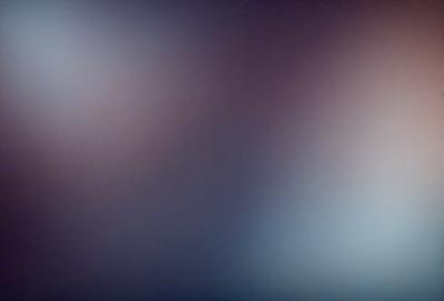 The primary subject of the image is a purple background with a blurry, colorful, and abstract design. The setting appears to be a dark room, and the visual style is a combination of digital art and illustration. The dominant colors in the image are purple and blue, creating a moody and artistic atmosphere.
