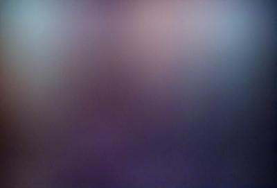 The primary subject of the image is a purple background with a blurry, out-of-focus face. The setting is a purple sky, and the visual style appears to be a digital art or illustration. The colors and mood of the image are predominantly purple, creating a somewhat mysterious and dreamy atmosphere.