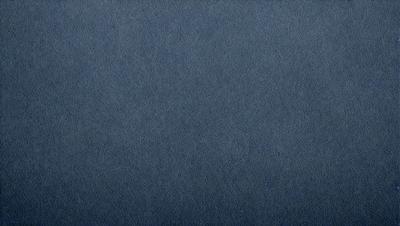 The primary subject of the image is a blue fabric, which appears to be a piece of denim. The setting is a blue background, which creates a contrast with the fabric. The visual style is a close-up of the denim fabric, showcasing its texture and details. The colors and mood of the image are predominantly blue, giving it a calm and serene atmosphere.