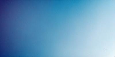 The primary subject of the image is a large, open blue sky. The setting is a vast, cloudless expanse, with no visible landmarks or objects. The visual style is a natural, untouched landscape, with no indication of digital manipulation or artistic elements. The colors and mood are predominantly blue, conveying a sense of tranquility and vastness.