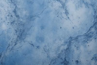 The primary subject of the image is a blue marble wall with a pattern of white spots. The setting is a room with a blue marble floor. The visual style is a close-up of the marble wall, showcasing the unique pattern of the spots. The colors and mood of the image are predominantly blue, with the white spots adding a touch of contrast and interest to the overall atmosphere.