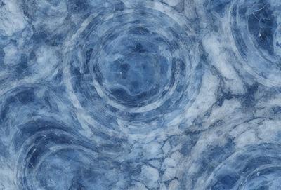 The primary subject of the image is a blue marble surface with a pattern of circles. The setting is a blue and white marble background, which adds to the visual style. The circles on the marble surface create a unique and intricate pattern, giving the image a distinct and artistic visual style. The overall atmosphere is calm and serene, with the blue and white marble providing a sense of tranquility and beauty.