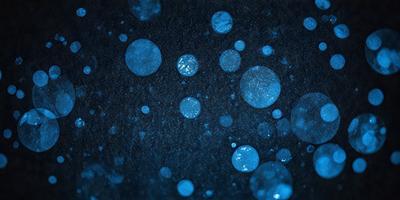 The primary subject of the image is a blue background with blue bubbles or circles scattered across it. The setting appears to be a dark or black background, which contrasts with the blue bubbles. The visual style of the image is a combination of a photo and digital art, as the blue bubbles have a slightly digital appearance. The overall atmosphere of the image is calm and serene, with the blue bubbles creating a sense of depth and intrigue.