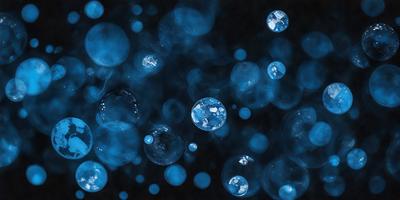 The primary subject of the image is a close-up of a blue, bubbly, and sparkling substance, which appears to be a blue liquid or a blue-tinted glass. The setting is a dark background, which contrasts with the blue substance, creating a visually striking scene. The visual style of the image is a close-up, focusing on the details of the blue substance. The colors and mood of the image are predominantly blue, creating a sense of depth and tranqu