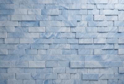 The primary subject of the image is a blue marble wall with a pattern of blue and white tiles. The setting is a room with a blue marble wall as the main focus. The visual style is a close-up of the blue marble wall, showcasing the intricate pattern of the tiles. The colors and mood of the image are predominantly blue, creating a calm and serene atmosphere.
