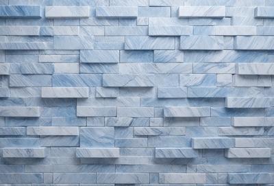 The primary subject of the image is a blue marble wall with a pattern of blue and white tiles. The setting is a room with a blue marble wall as the main focus. The visual style is a close-up of the blue marble wall, showcasing the intricate pattern of the tiles. The colors and mood of the image are predominantly blue and white, creating a calm and elegant atmosphere.