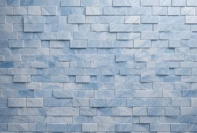 The primary subject of the image is a blue brick wall. The setting is a blue brick wall with a pattern of blue and white bricks. The visual style is a photo of the blue brick wall. The dominant colors are blue and white, creating a calm and soothing atmosphere.