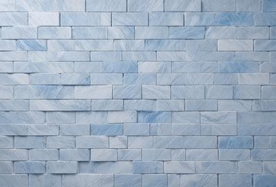 The primary subject of the image is a blue brick wall. The setting is a room with a blue brick wall as the main focus. The visual style is a photo, and the dominant colors are blue and white. The overall atmosphere is calm and serene.