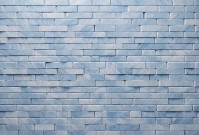 The primary subject of the image is a blue brick wall. The setting is a room with a blue brick wall as the main focus. The visual style is a photo, and the dominant colors are blue and white. The overall atmosphere is calm and serene.