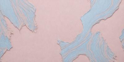 The primary subject of the image is a piece of blue fabric, possibly a piece of clothing or a decorative item. The setting is a pink background, which creates a contrast between the blue fabric and the pink surface. The visual style of the image is a close-up of the fabric, showcasing its texture and details. The colors and mood of the image are predominantly blue and pink, giving it a calm and soothing atmosphere.