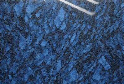 The primary subject of the image is a blue marble surface, which appears to be a stone or a marble tile. The setting is a room with a blue marble wall, and the visual style is a close-up of the marble surface. The colors and mood of the image are predominantly blue, creating a calm and serene atmosphere.