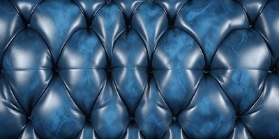The primary subject of the image is a blue leather couch with a patterned design. The setting is a room with a blue background, and the visual style is a close-up of the couch. The colors and mood of the image are predominantly blue, creating a calm and relaxing atmosphere.