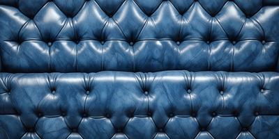 The primary subject of the image is a blue leather couch. The setting is a room with a blue background. The visual style is a photo, and the colors and mood are predominantly blue, creating a calm and relaxing atmosphere.