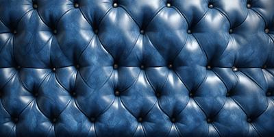 The primary subject of the image is a blue leather couch with a patterned design. The setting is a room with a blue background, and the visual style is a close-up of the couch. The colors and mood of the image are predominantly blue, creating a calm and relaxing atmosphere.