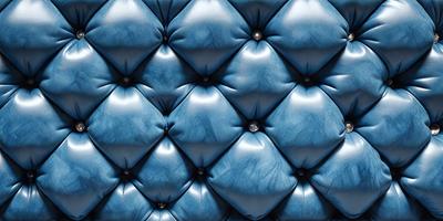 The primary subject of the image is a blue leather couch with a patterned design. The setting is a room with a blue background, and the visual style appears to be a photo. The dominant colors in the image are blue and white, creating a calm and relaxing atmosphere.