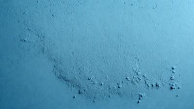 The primary subject of the image is a blue surface with a pattern of bubbles or dots on it. The setting appears to be a wall or a similar surface. The visual style of the image is a close-up of the blue surface, which gives it a textured and detailed appearance. The dominant colors in the image are blue and white, creating a calm and soothing atmosphere.