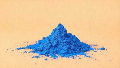 The primary subject of the image is a pile of blue powder, which is likely a type of paint or dye. The setting is a white surface, which provides a clean and uncluttered backdrop for the blue powder. The visual style of the image is a close-up, focusing on the details of the blue powder. The colors and mood of the image are predominantly blue, creating a calm and serene atmosphere.