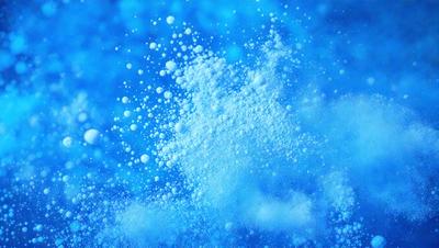 The primary subject of the image is a cloud of white powder, which appears to be snow or a similar substance. The setting is a blue sky, creating a contrasting backdrop for the cloud. The visual style of the image is a close-up of the cloud, emphasizing its texture and details. The dominant colors in the image are blue and white, creating a serene and peaceful atmosphere.
