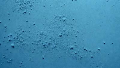 The primary subject of the image is a blue surface with a pattern of bubbles or droplets on it. The setting appears to be a blue background, and the visual style is a close-up of the blue surface. The colors and mood of the image are predominantly blue, creating a calm and serene atmosphere.