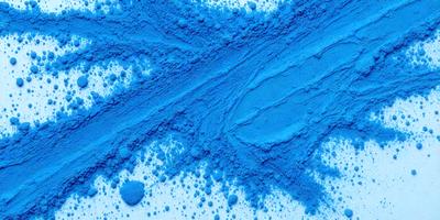 The primary subject of the image is a close-up of a blue substance, possibly a powder or a liquid, with a swirling pattern. The setting is a white surface, which provides a clean and contrasting background. The visual style appears to be a close-up of a powder or a liquid, possibly a digital art or an illustration. The dominant colors are blue and white, creating a calm and soothing atmosphere.