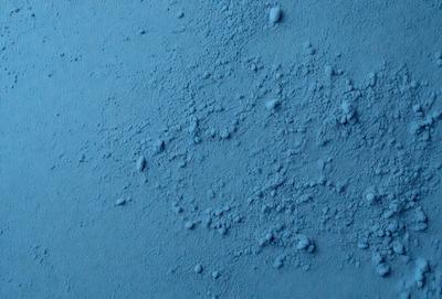 The primary subject of the image is a blue surface with a pattern of bubbles or dots on it. The setting appears to be a blue wall or a blue background. The visual style of the image is a close-up of the blue surface, showcasing the bubbles or dots. The colors and mood of the image are predominantly blue, creating a calm and serene atmosphere.