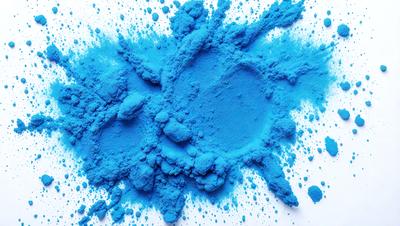 The primary subject of the image is a blue powder, which is likely a pigment or a dye. The setting is a white surface, possibly a table or a wall, where the blue powder is spread out. The visual style of the image is a close-up of the blue powder, showcasing its texture and color. The dominant colors in the image are blue and white, creating a calm and serene atmosphere.