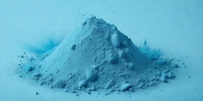 The primary subject of the image is a large pile of blue powder, which appears to be a mix of blue and white colors. The setting is a white background, which provides a clean and uncluttered appearance. The visual style of the image is a close-up of the powder, showcasing its texture and details. The colors and mood of the image are predominantly blue and white, creating a sense of calmness and tranquility.