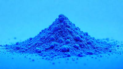 The primary subject of the image is a blue substance, possibly a powder or a liquid, that is piled up in a mountain-like shape. The setting is a blue background, which creates a striking contrast with the blue substance. The visual style appears to be a close-up of the blue substance, showcasing its unique texture and appearance. The colors and mood of the image are predominantly blue, giving it a calm and serene atmosphere.