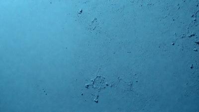 The primary subject of the image is a blue surface with a pattern of dots. The setting is a blue background, and the visual style appears to be a photo. The dominant colors are blue and white, creating a calm and serene atmosphere.