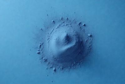 The primary subject of the image is a blue, circular object that appears to be a blue powder or a blue substance. The setting is a blue surface, which could be a wall or a table. The visual style of the image is a close-up of the blue circular object, showcasing its texture and color. The dominant colors in the image are blue, and the overall atmosphere is calm and serene.