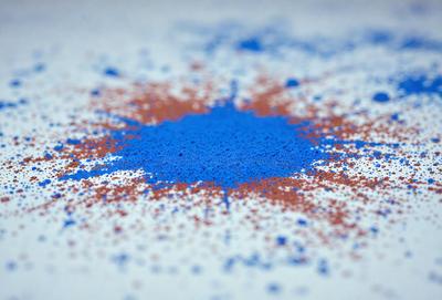 The primary subject of the image is a blue and red circle, which is the main object, scene, or focus of the image. The circle is placed on a white surface, which serves as the setting or background. The visual style of the image is a combination of photo and digital art, as it appears to be a close-up of a blue and red circle with a patterned background. The colors and mood of the image are predominantly blue and red, creating a vibrant and lively atmosphere.