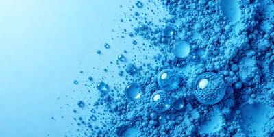 The primary subject of the image is a close-up of a blue substance, possibly a powder or a liquid, with a lot of bubbles. The setting is a white background, which provides a clean and uncluttered appearance. The visual style is a close-up, which emphasizes the details of the blue substance and the bubbles. The colors and mood of the image are predominantly blue, which gives it a calm and soothing atmosphere.