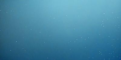The primary subject of the image is a blue sky with white stars scattered throughout. The setting is a vast, open space with no visible landmarks or objects. The visual style is a combination of a photo and a drawing, creating a unique and artistic representation of the night sky. The colors and mood of the image are predominantly blue and serene, evoking a sense of tranquility and wonder.
