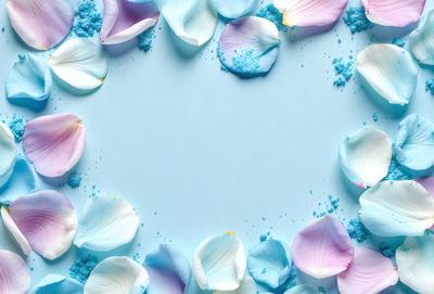 The primary subject of the image is a bouquet of flowers, specifically white and pink flowers, arranged in a circle on a blue surface. The setting appears to be a studio or a controlled environment, as the flowers are placed in a deliberate manner. The visual style of the image is a combination of photo and digital art, creating a vibrant and lively atmosphere. The dominant colors in the image are blue and pink, which contribute to the overall mood of the scene.