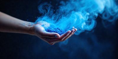 The primary subject of the image is a person's hand holding a small amount of blue powder. The setting is a dark background, which contrasts with the blue powder and the person's hand. The visual style appears to be a close-up of the person's hand, with the blue powder being the main focus. The colors and mood of the image are predominantly dark and mysterious, with the blue powder adding a touch of brightness and intrigue.
