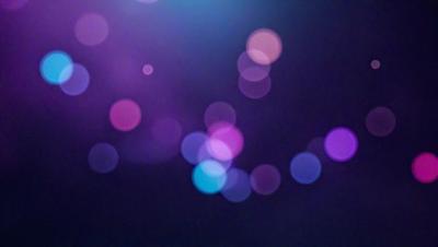 The primary subject of the image is a purple background with a pattern of bright, colorful lights. The setting appears to be a dark room, and the visual style is a combination of a photo and digital art. The colors and mood of the image are vibrant and lively, with the purple background and the bright lights creating a captivating and energetic atmosphere.