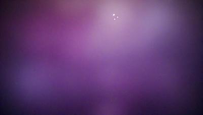 The primary subject of the image is a purple background with a few white lights in the distance. The setting appears to be a dark room with a purple hue. The visual style of the image is a combination of a photo and digital art, creating a unique and artistic atmosphere. The colors and mood of the image are predominantly purple, with the white lights adding a touch of brightness and contrast to the overall scene.