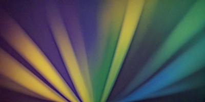 The primary subject of the image is a colorful, rainbow-like pattern. The setting is a dark background, which contrasts with the vibrant colors of the pattern. The visual style appears to be a combination of digital art and illustration, creating a unique and eye-catching design. The dominant colors in the image are yellow, green, and purple, which contribute to a lively and cheerful atmosphere.