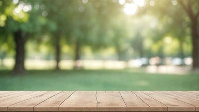 The primary subject of the image is a wooden bench situated in a park. The bench is placed on a grassy field, surrounded by trees. The setting is a serene, natural environment, perfect for relaxation and enjoying the outdoors. The visual style of the image is a photo, capturing the beauty of the park and the wooden bench. The colors and mood of the image are predominantly green and calm, reflecting the peaceful atmosphere of the park.