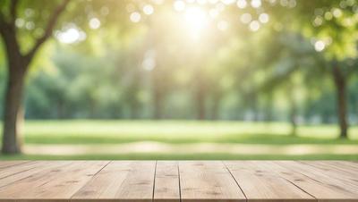 The primary subject of the image is a wooden bench, which is the main object in the scene. The setting is a grassy field with trees in the background, creating a serene and natural atmosphere. The visual style is a photo, capturing the outdoor environment and the wooden bench. The colors and mood of the image are predominantly green and calm, reflecting the peaceful and relaxing ambiance of the scene.