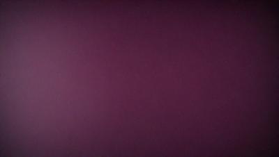 The primary subject of the image is a purple wall. The setting is a room with a purple wall, and the visual style is a close-up of the wall. The colors and mood of the image are predominantly purple, creating a calm and serene atmosphere.