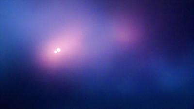 The primary subject of the image is a purple sky with two bright stars shining through it. The setting is a cloudy sky, and the visual style appears to be a photo. The dominant colors are purple and blue, creating a serene and peaceful atmosphere.