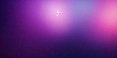 The primary subject of the image is a purple sky with a crescent moon and two planets visible. The setting is a space background, and the visual style appears to be a photo. The colors and mood of the image are predominantly purple, creating a serene and celestial atmosphere.