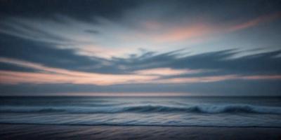 The primary subject of the image is the ocean, with waves crashing on the shore. The setting is a beach, and the visual style is a photo. The colors and mood of the image are predominantly dark, with a hint of blue from the ocean.