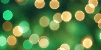 The primary subject of the image is a close-up of a green background with a pattern of bright, glowing lights. The lights are scattered throughout the scene, creating a visually appealing and lively atmosphere. The setting appears to be a dark room, with the lights providing a contrasting and captivating visual effect. The overall mood of the image is energetic and vibrant, with the glowing lights serving as the main focus of the scene.