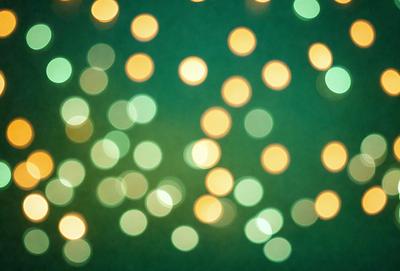The primary subject of the image is a close-up of a green background with a pattern of yellow lights. The setting appears to be a dark room, and the visual style is a combination of a photo and digital art. The dominant colors are green and yellow, creating a warm and inviting atmosphere.