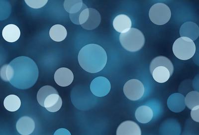 The primary subject of the image is a blue background with a pattern of white circles. The setting appears to be a night sky, creating a serene and peaceful atmosphere. The visual style of the image is a combination of a photo and digital art, as it features a blend of natural elements and artistic design. The dominant colors in the image are blue and white, with the white circles creating a sense of depth and contrast against the blue background.